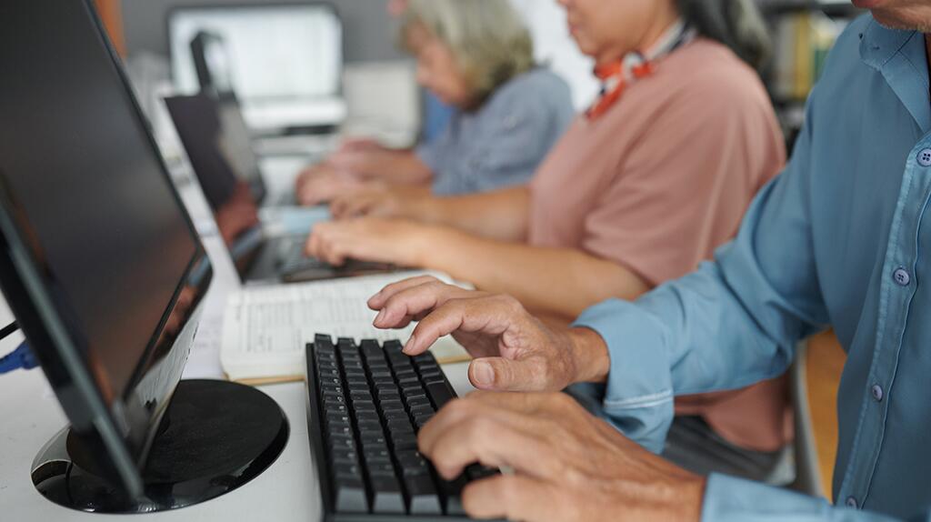 Mensen typen op computers in een kantooromgeving.