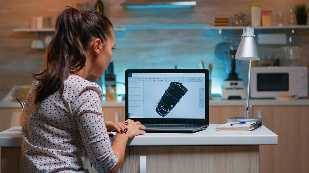 Vrouw werkt op laptop in keuken, 3D-ontwerp op scherm.