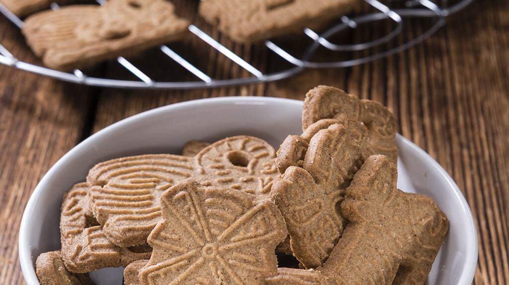 Schaal met speculaaskoekjes op houten tafel.