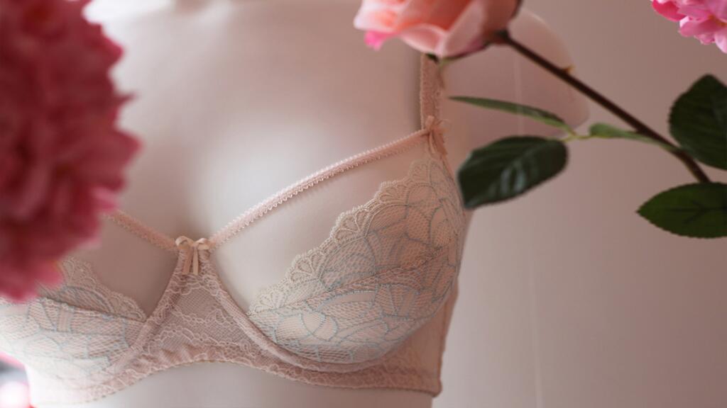 Beha op paspop omringd door roze bloemen.