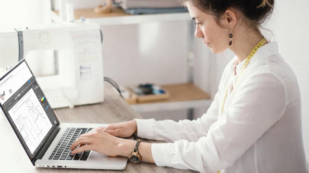 Vrouw typt op een laptop in een lichte kamer.