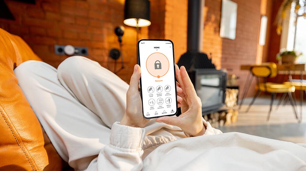 Persoon ligt op bank, kijkt naar een smartphone met een app geactiveerd.