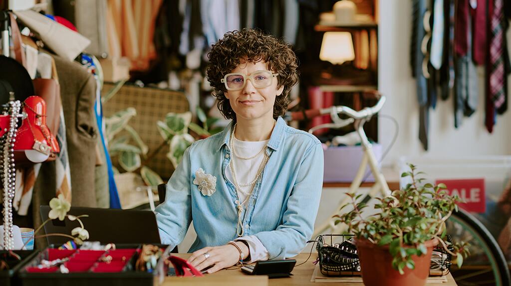 Vintage winkel met glimlachende vrouw achter de toonbank.