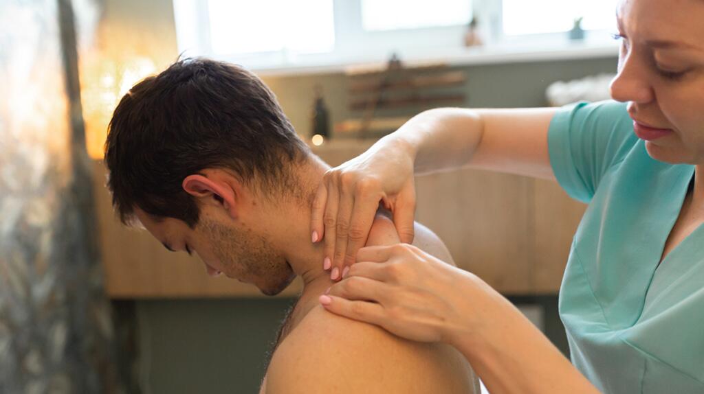Man krijgt een nek- en schoudermassage.