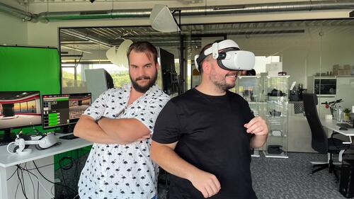 Twee mannen in een kantoor; één draagt een VR-bril, de ander staat met gekruiste armen.