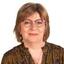 Vrouw met bril en halflang haar, glimlachend.