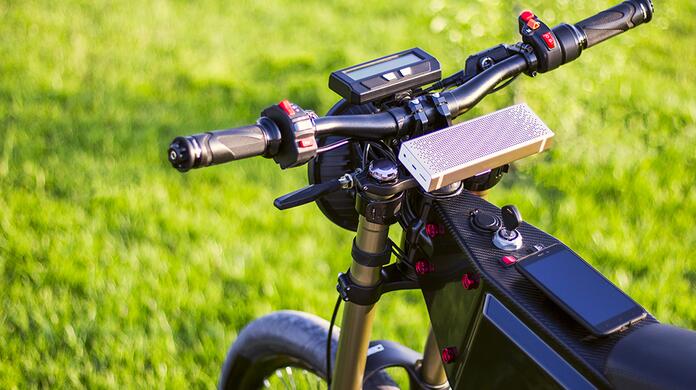 Stuur van een elektrische mountainbike op gras.