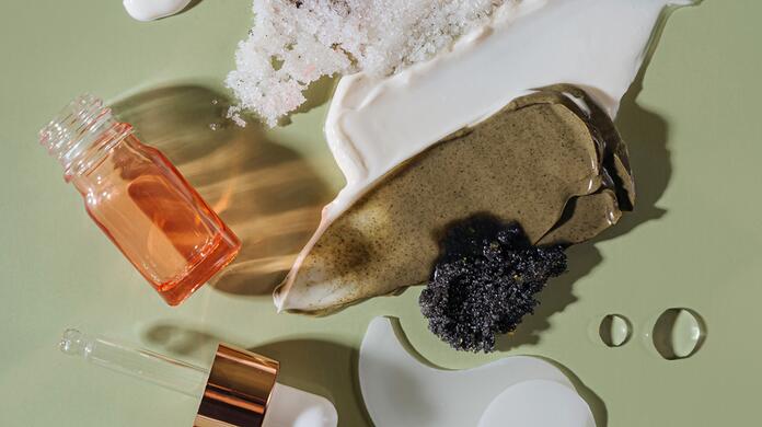 Cosmetische items en crèmes op groene achtergrond.