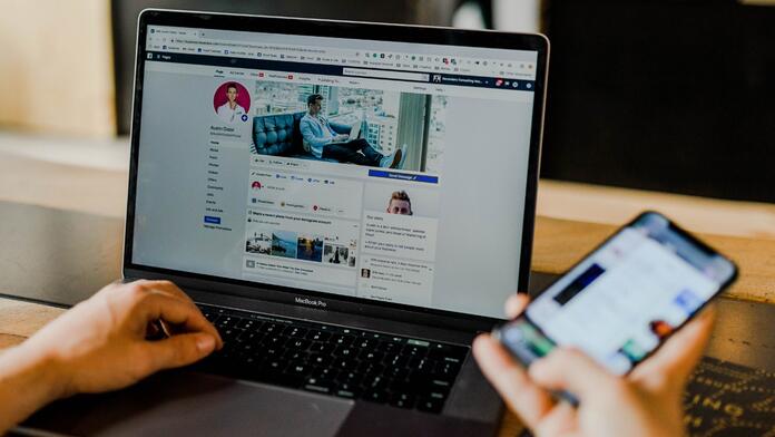 Laptop en smartphone met sociale media open.