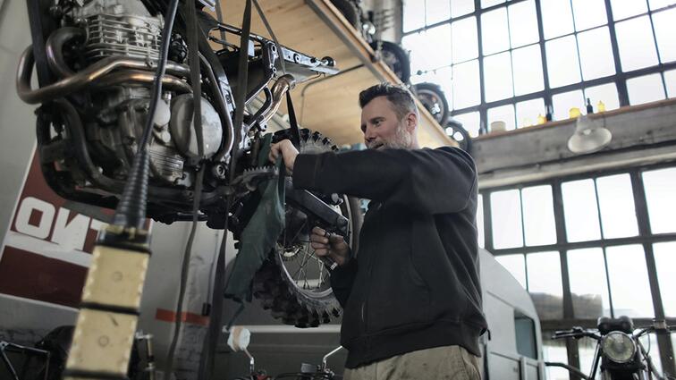 Man werkt aan motor in lichte werkplaats.